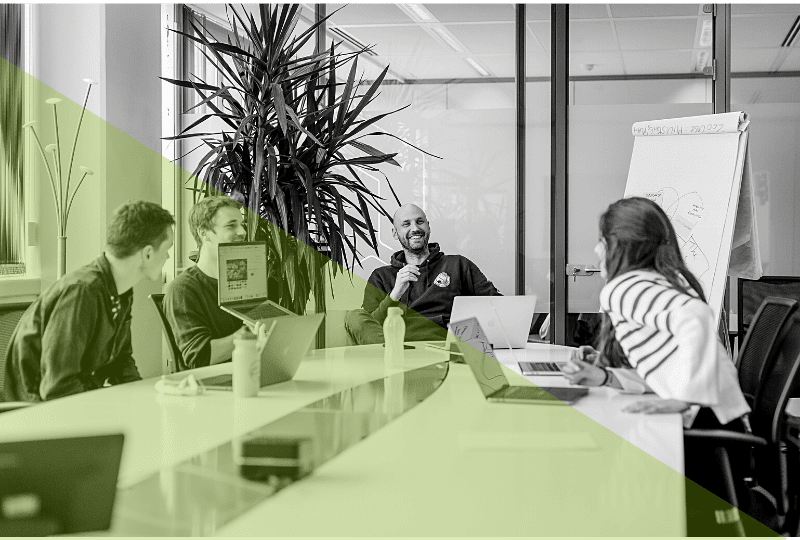 4 people in a meeting room working together
